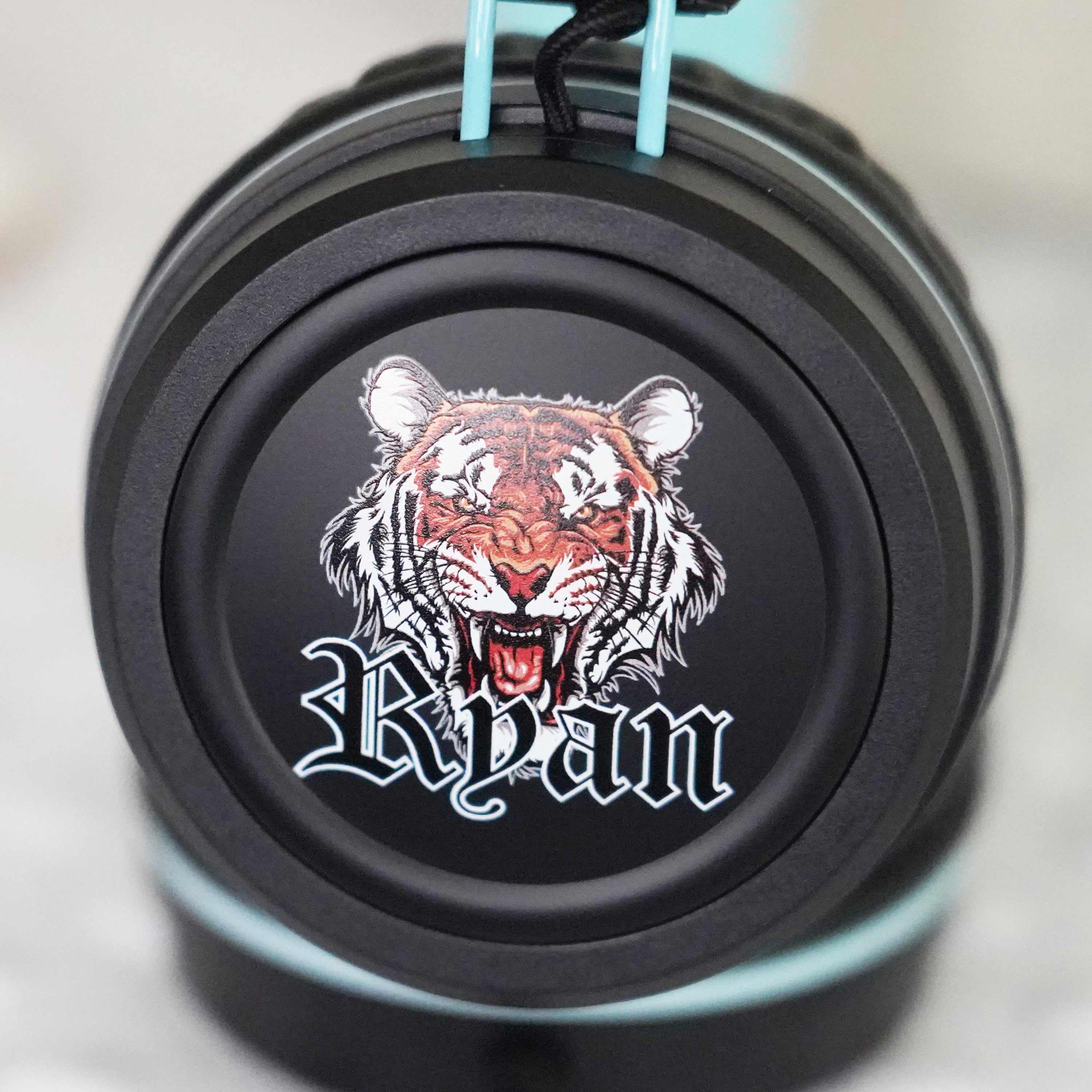 Black KidJamz KJ55AUX headphones faceplate with a Tiger and custom name design in color on a light gray background