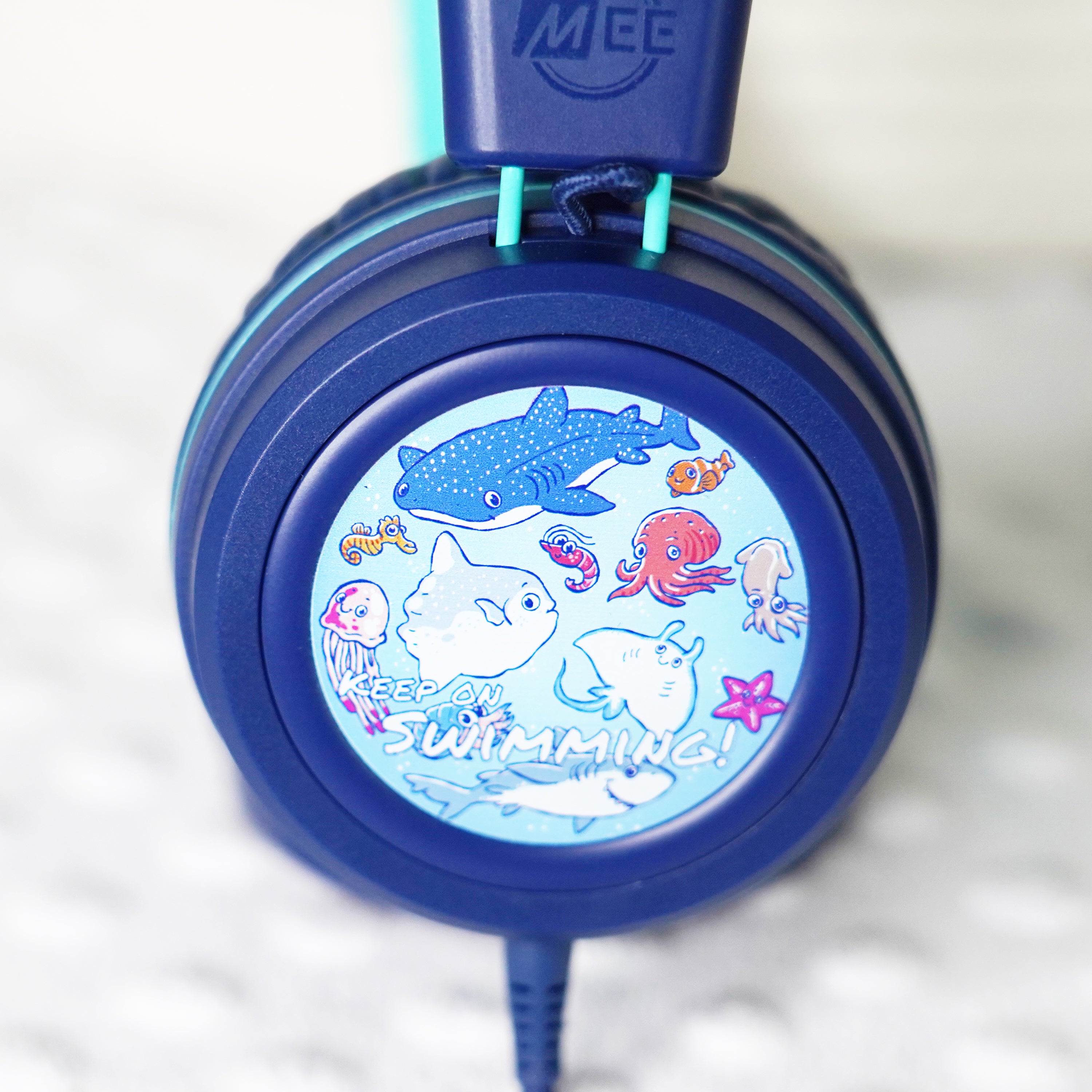 Blue KidJamz KJ55AUX headphones faceplate with a cartoon ocean life design on a light gray background