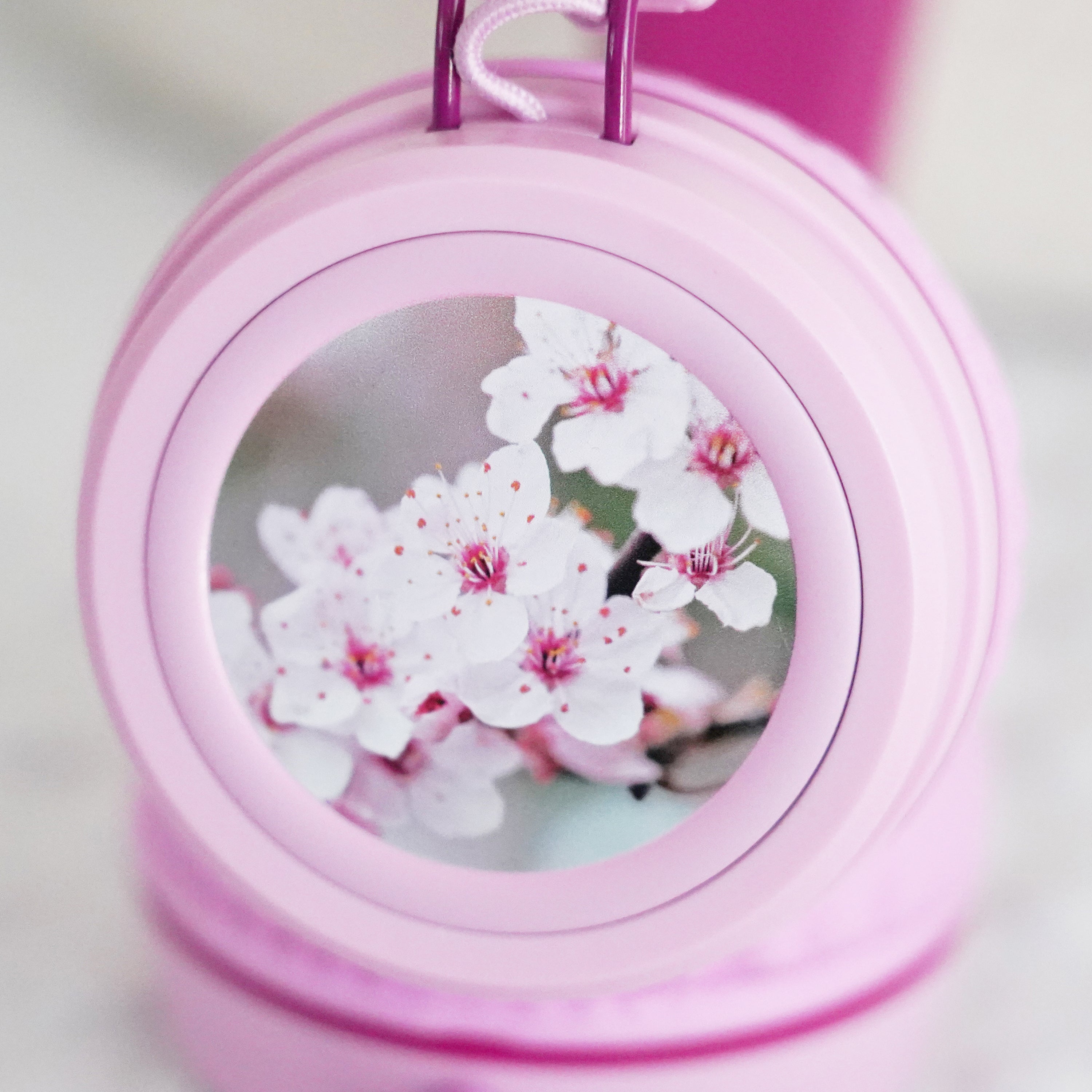 Pink KidJamz KJ55AUX headphones faceplate with a cherry blossom design in color on a light gray background