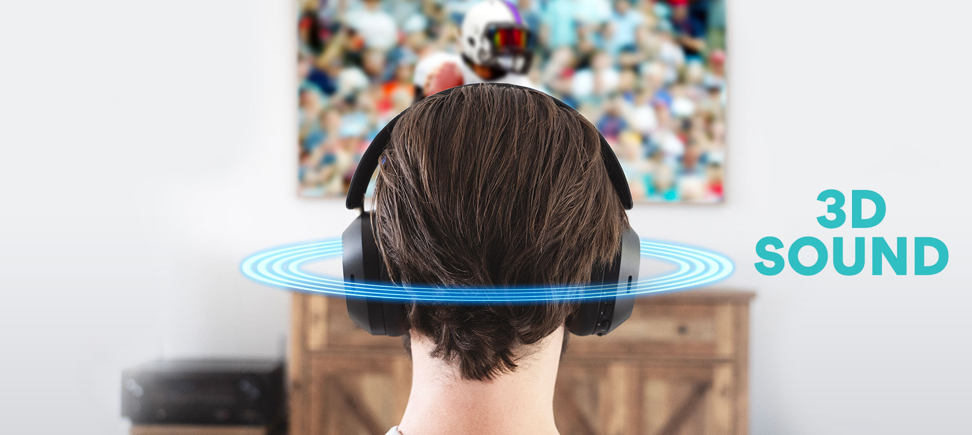 A man wearing 3D sound headphones with a TV displaying sports in the background