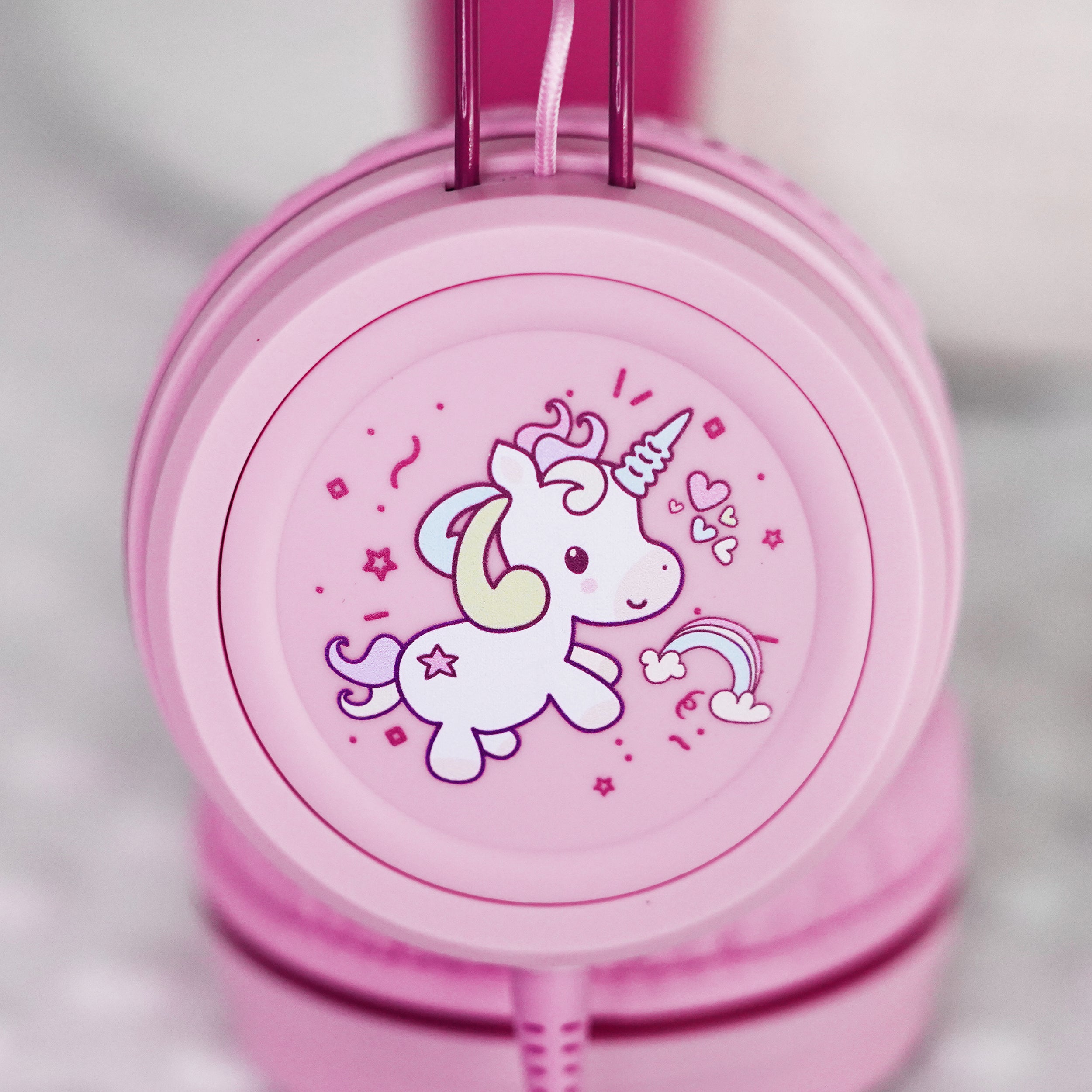 Pink KidJamz KJ55AUX headphones faceplate with a cartoon unicorn design in color on a light gray background