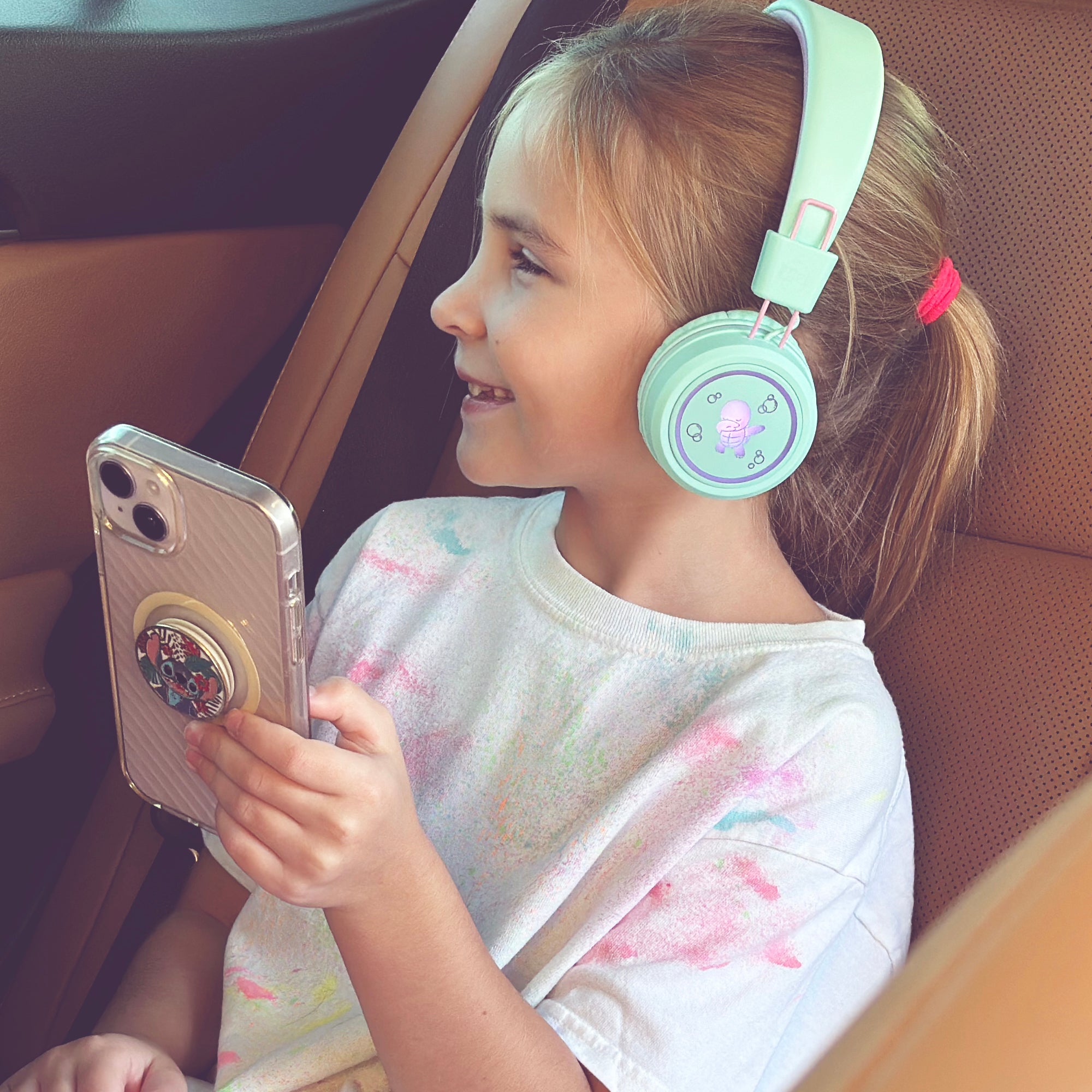 Image of a girl wearing the MEE audio KidJamz KJ55BT Bluetooth Wireless Safe Listening Headphones for Children with LED Lights, 85dB Volume Limiter, Microphone, & 40h battery; Kids Headset for School / iPhone / iPad / Tablet