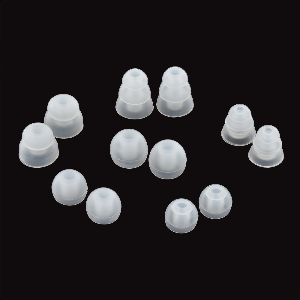 A collection of various sizes of white, translucent earbud tips spread out on a black background.