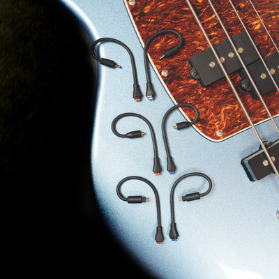 The MEE audio BT3 Bluetooth wireless adapter cable comes with 3 interchangeable connectors to fit a wide range of popular in-ear monitors: MMCX, 2-pin (0.78 mm), and DC, displayed on a guitar. 