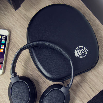 Matrix Cinema Headphones resting on Premium Carrying Case next to a cell phone on a wood surface