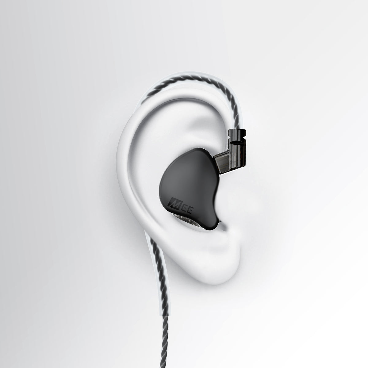A black MEE audio CORE 2 dual hybrid driver in-ear monitor earpiece with a braided cable and connector, shown mounted on a white stylized ear model against a light gray background.