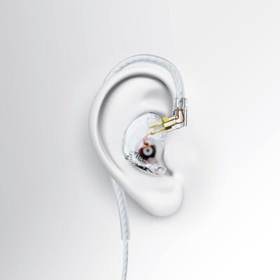 A clear MEE audio CORE 2 dual hybrid driver in-ear monitor earpiece with a transparent outer shell, gold and silver internal components, and a white cable, shown on a white ear form against a light gray background.