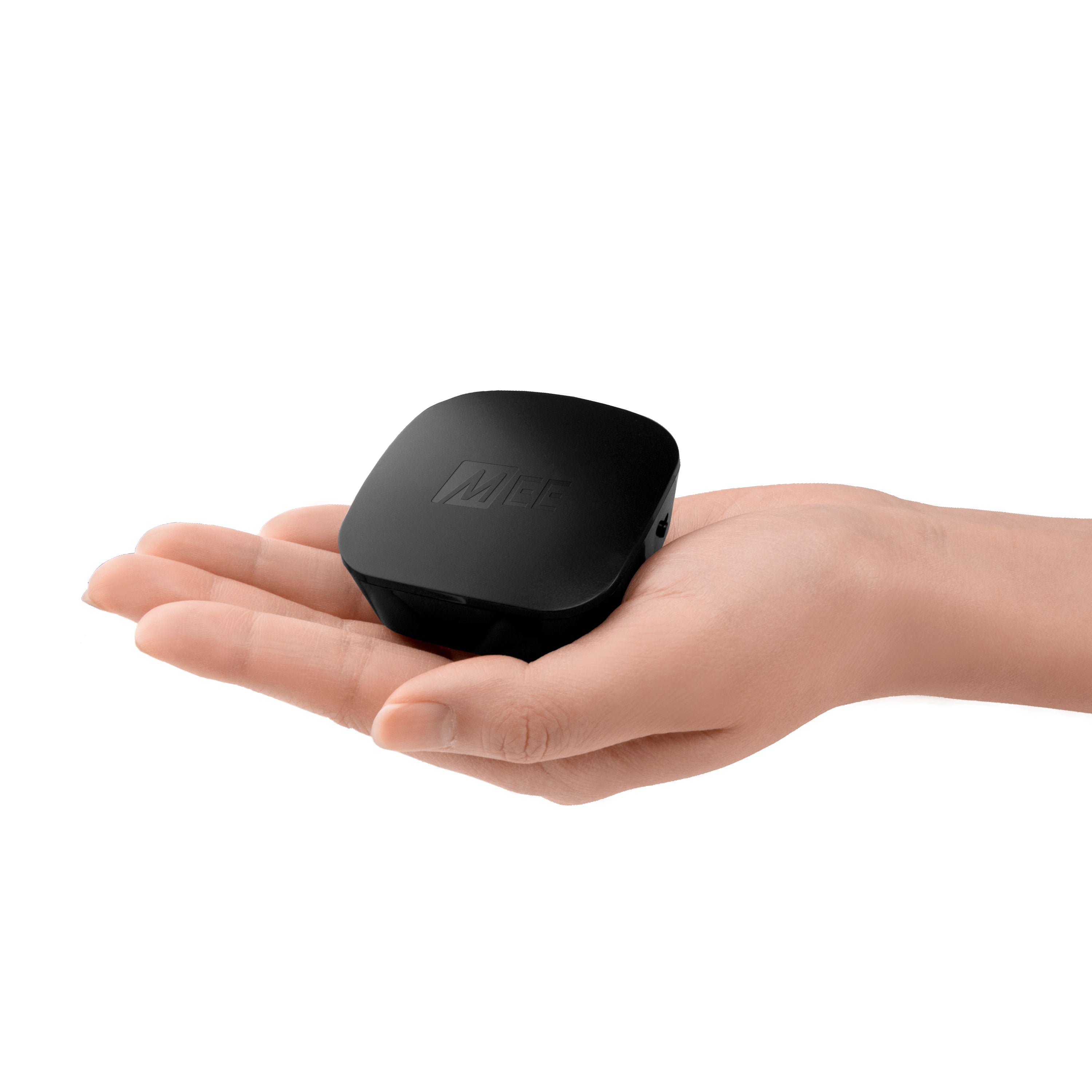 A human hand holds a small, black, cube-shaped electronic device with a discreet logo on top, isolated against a white background.
