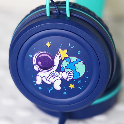 Blue KidJamz KJ55AUX headphones faceplate with a cartoon astronaut design holding a star while in outer space in color on a light gray background 