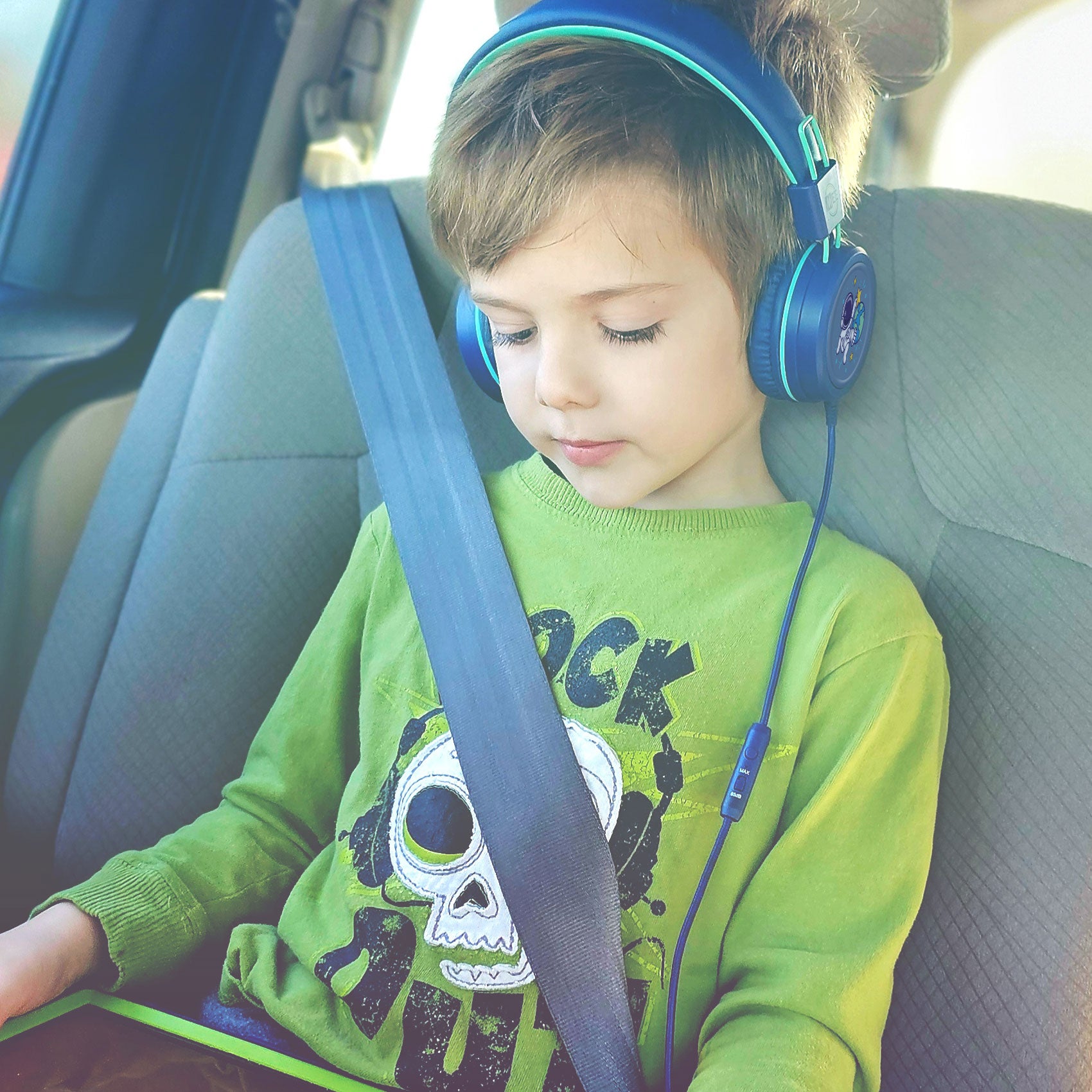Child wearing MEE audio KidJamz KJ55 Wired Children’s Headphones with 3.5mm Plug, Colorful Graphics, Volume Limiter & Microphone, Adjustable On-Ear Kids Headset for Online Learning/School/Travel/Tablet