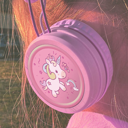 Pink KJ55AUX headphones with a unicorn design on a child's head.