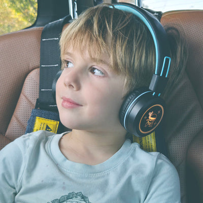 Image of a boy wearing MEE audio KidJamz KJ55BT Bluetooth Wireless Safe Listening Headphones for Children with LED Lights, 85dB Volume Limiter, Microphone, & 40h battery; Kids Headset for School / iPhone / iPad / Tablet