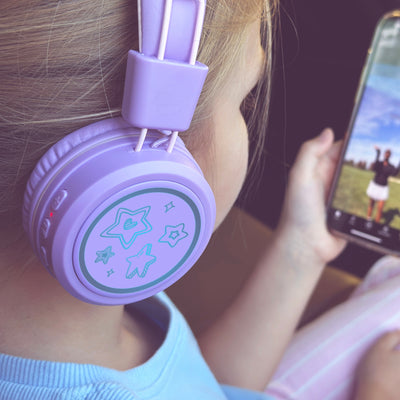 Image of a girl wearing the MEE audio KidJamz KJ55BT Bluetooth Wireless Safe Listening Headphones for Children with LED Lights, 85dB Volume Limiter, Microphone, & 40h battery; Kids Headset for School / iPhone / iPad / Tablet