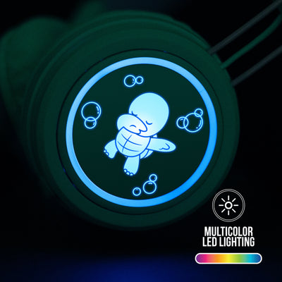 Multicolor LED lights on a Mint KJ55BT KidJamz Headphone
with 8 colors and patterns illuminate the cartoon turtle graphics on each ear cup with no batteries required on a dark background