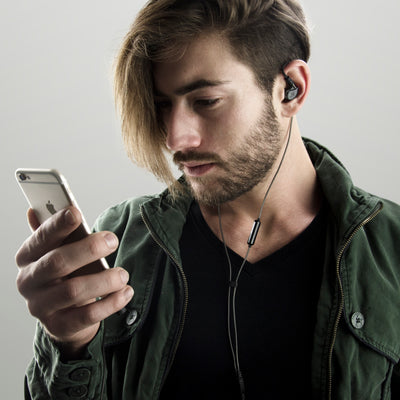 Musician wearing Black M6 PRO in-ear monitors while on the phone