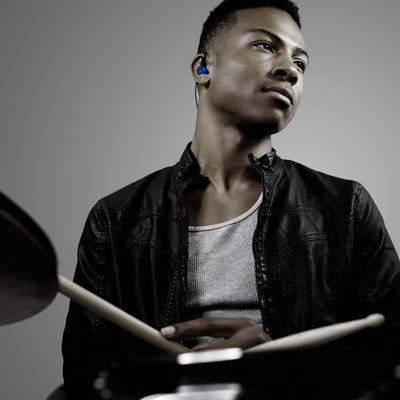 Drummer wearing the blue M6PRO in-ear monitors while playing the drums