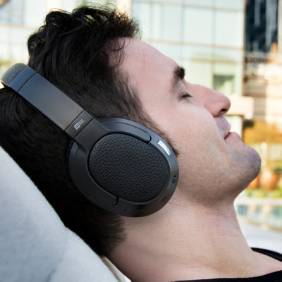 Man wearing MEE audio Matrix Cinema Bluetooth Wireless headphones with a cityscape background.