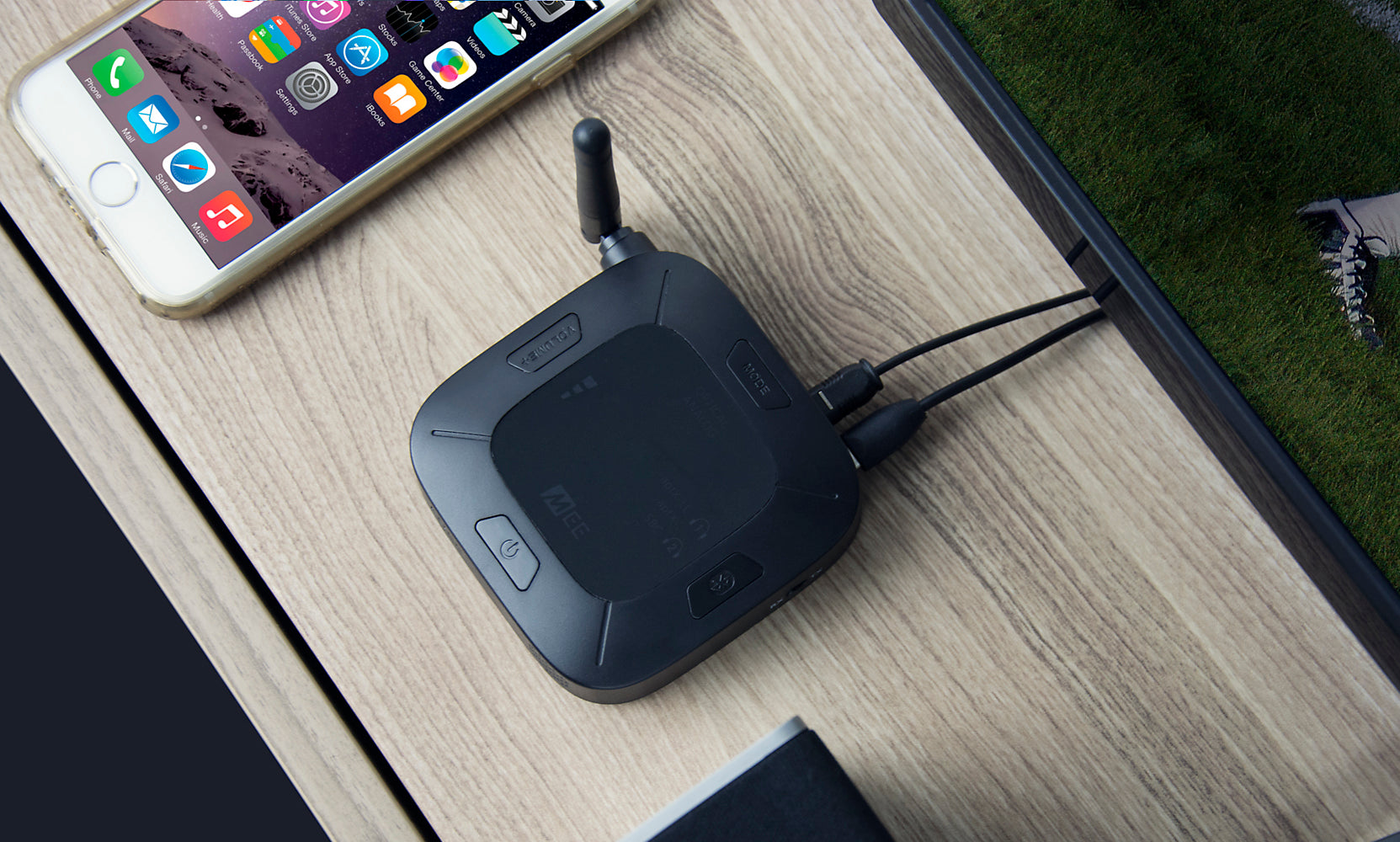 A wireless router and a smartphone on a wooden desk. the router has multiple antennas and cables, and the phone displays colorful app icons.